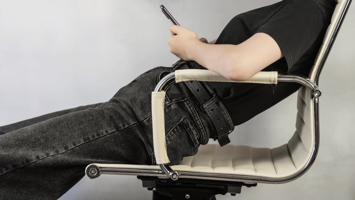 Person demonstrating good sitting posture on an ergonomic chair — active sitting