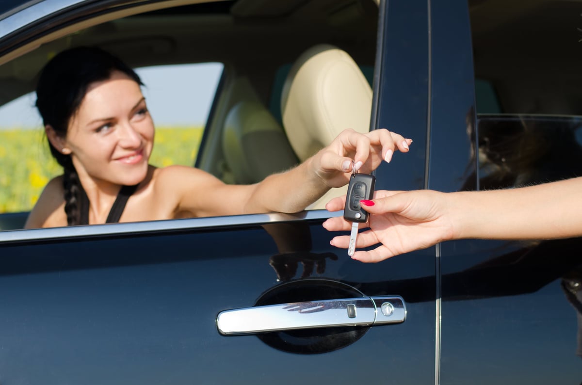 Person handing car keys for car sharing service