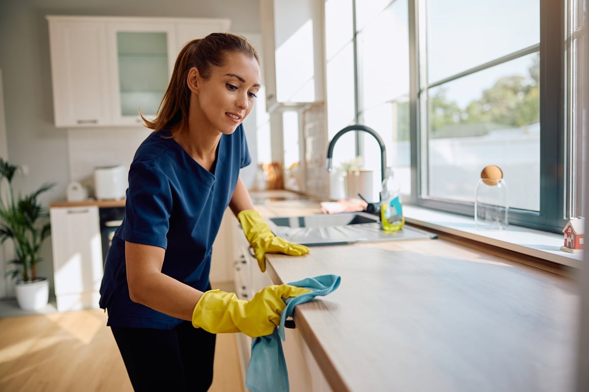 Professional cleaner wiping down kitchen counter