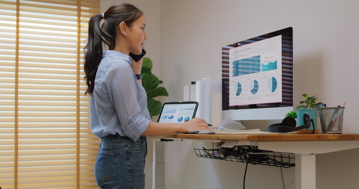 Electric adjustable standing desk in a small home office workspace