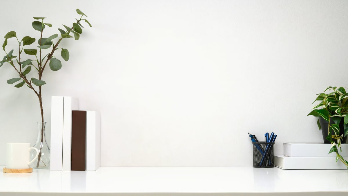 Minimalist workspace with books, plants, and organized shelves creating a beautiful background