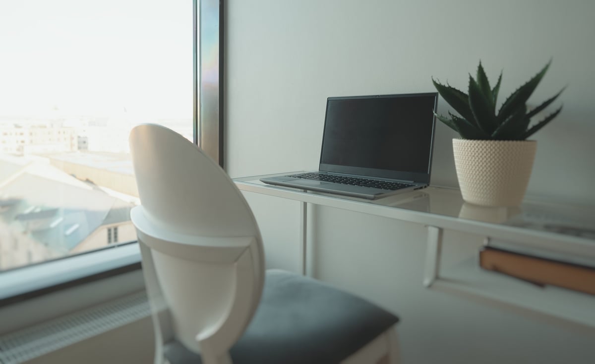 Laptop by the window in a cozy home office workspace with natural light