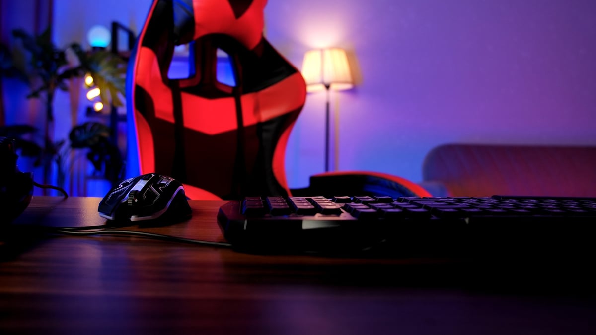 Stylish gaming desk setup with ambient soft lighting and comfortable chair