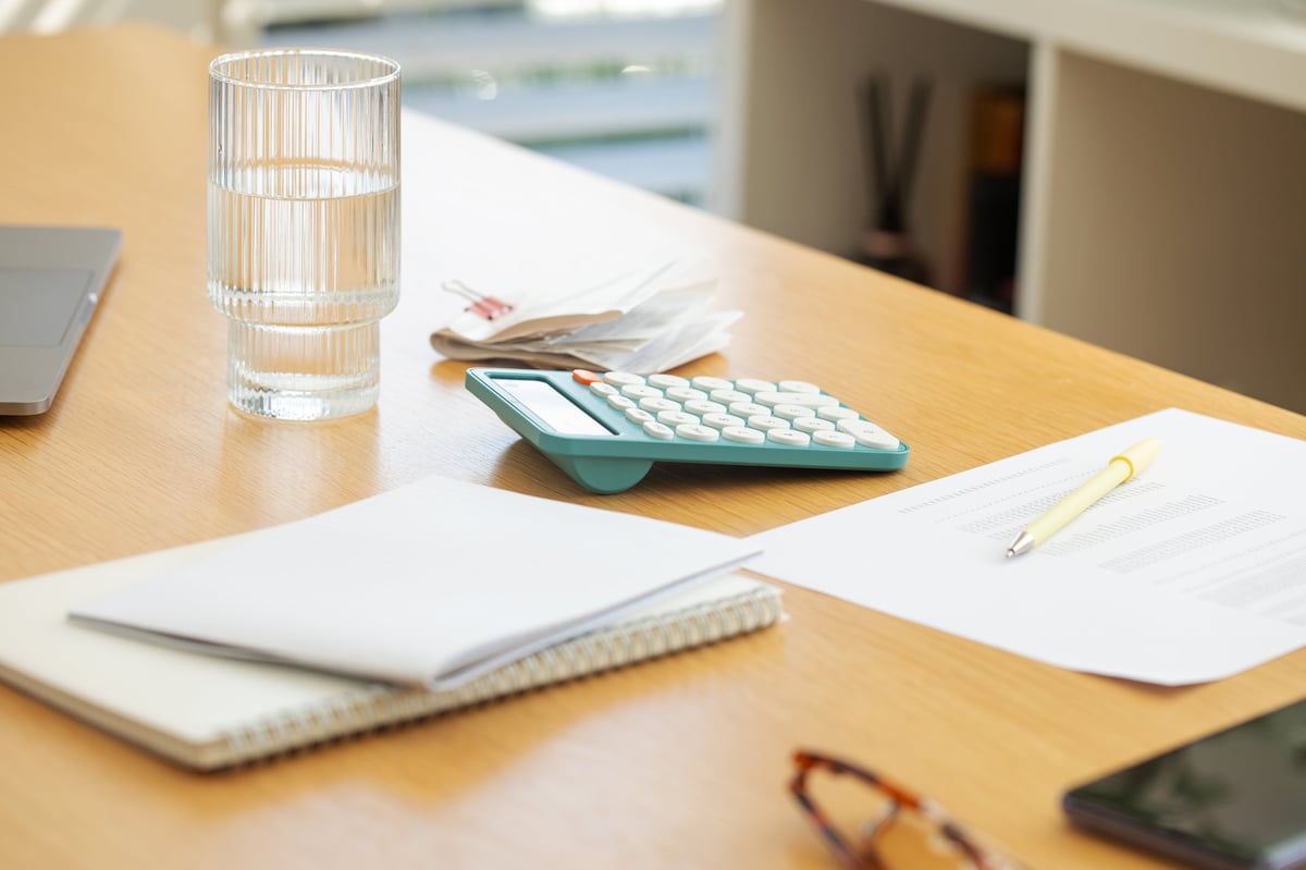 Workspace with laptop, calculator, and coffee — thoughtful budget home office planning
