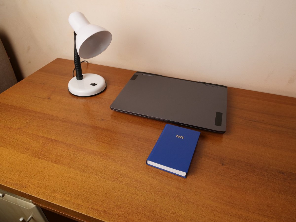Clean workspace with closed laptop, desk lamp, and planner — the full budget setup