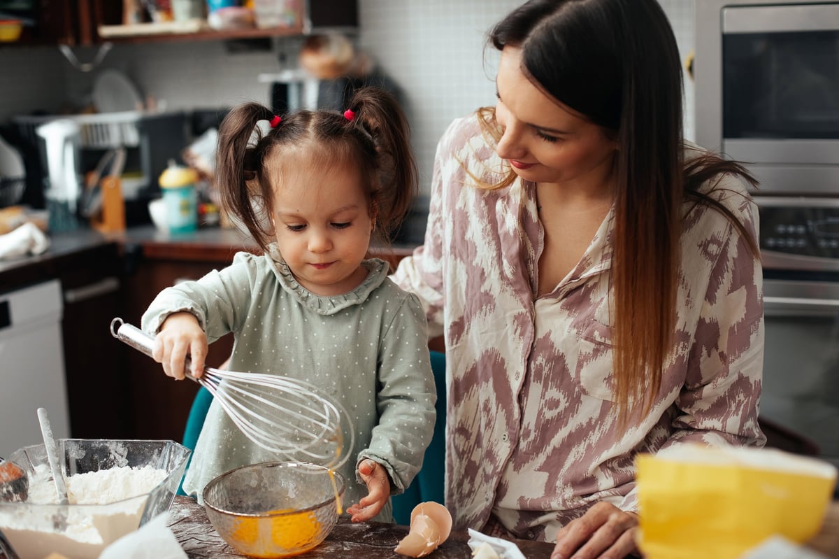 Mother and daughter baking together in home kitchen