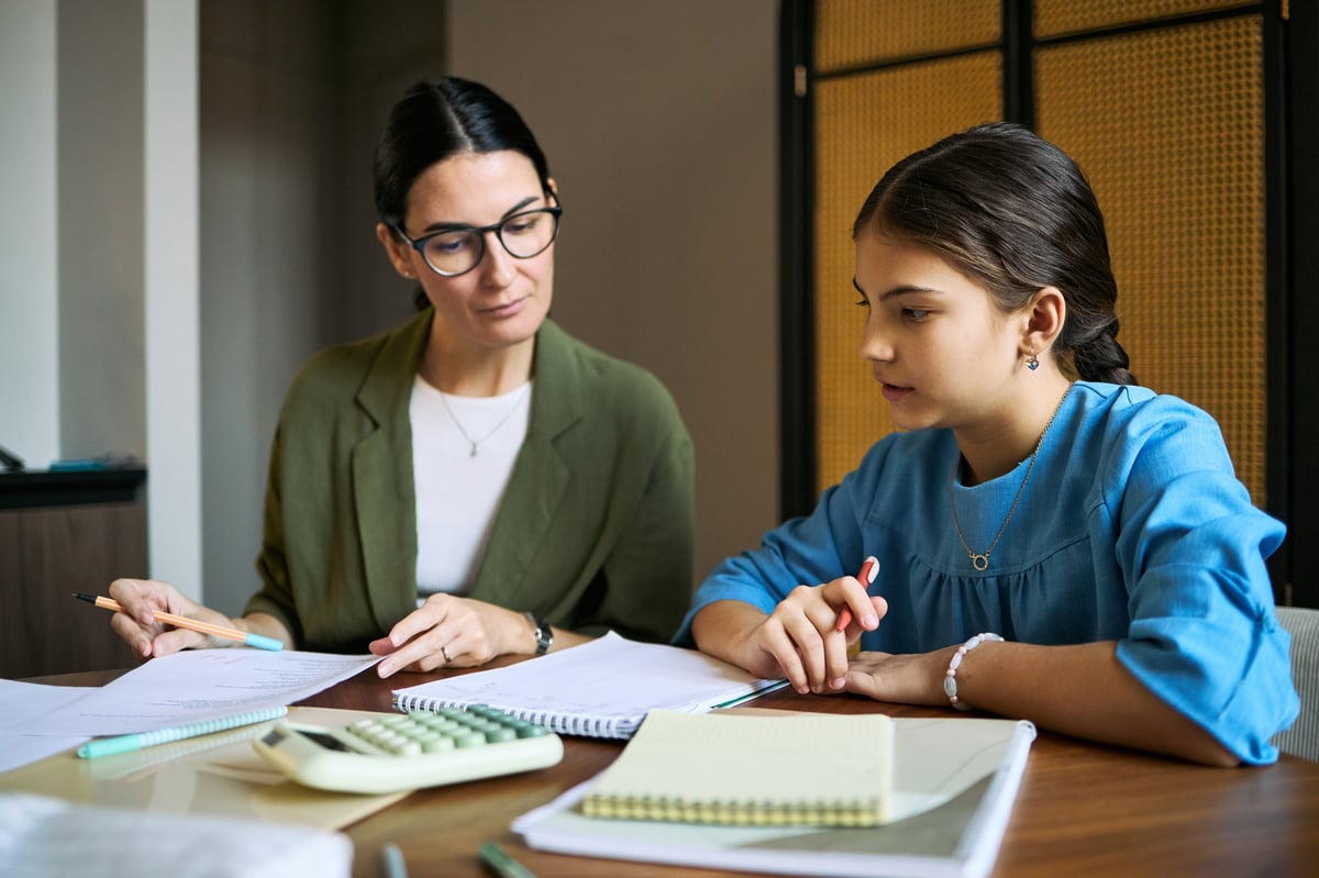 Tutor helping student with homework at desk