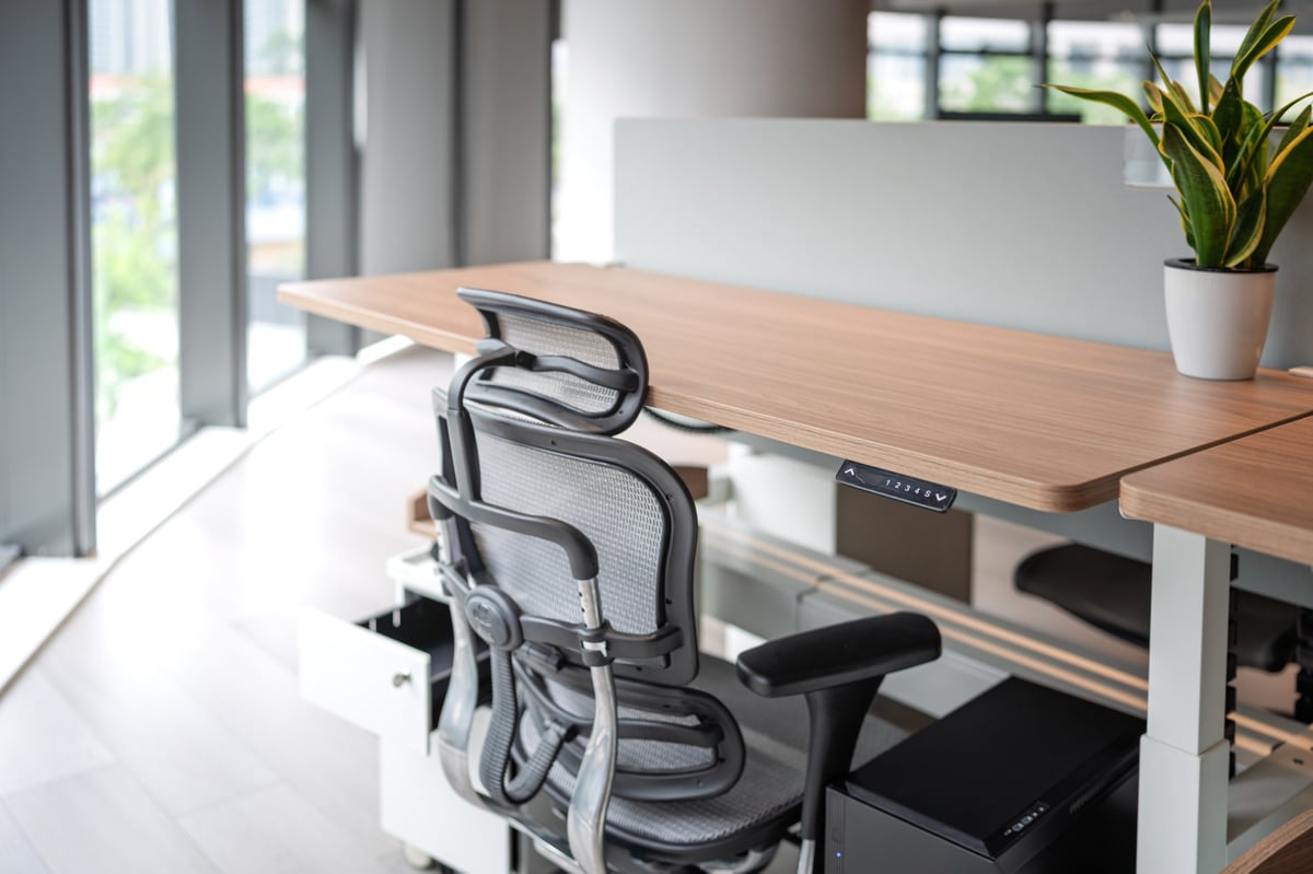 Ergonomic chair at adjustable standing desk in modern home office